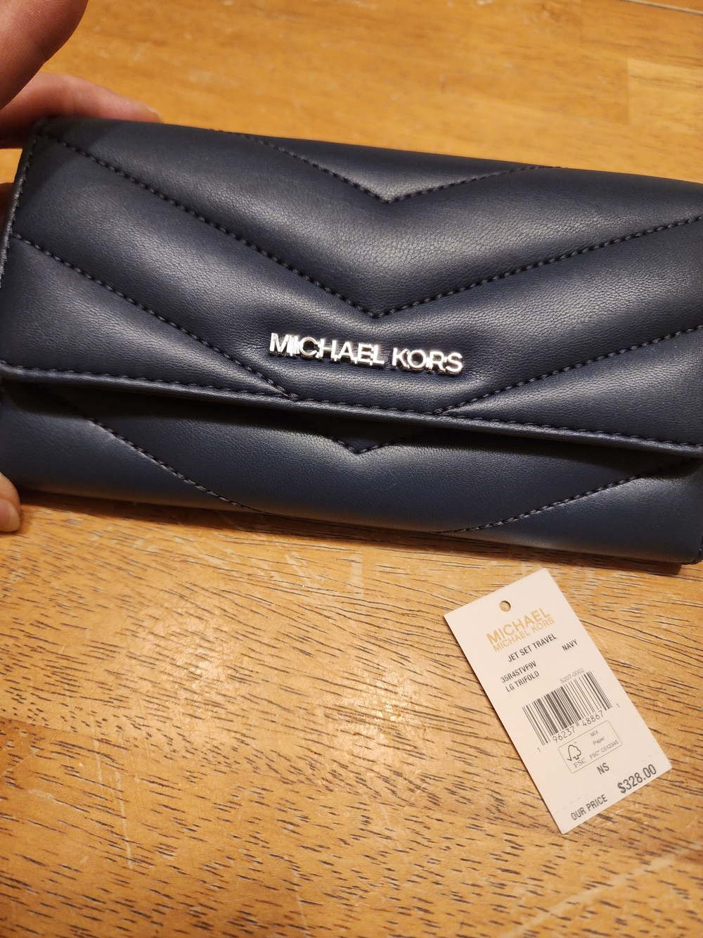 Michael Kors Jet Set Travel Large Quilted Tri-Fold Wallet in a navy blue color.